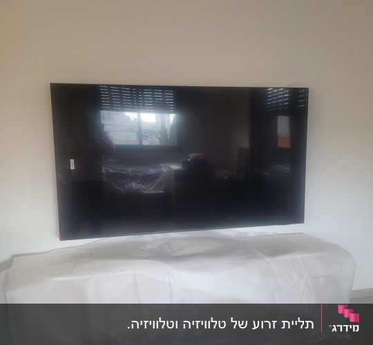 טלוויזיה מותקנת על קיר, רהיט מכוסה בניילון